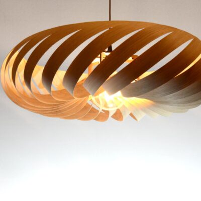 Suspension Vortex M en bois de chêne, luminaire sculptural aux lames courbées diffusant une lumière chaude.