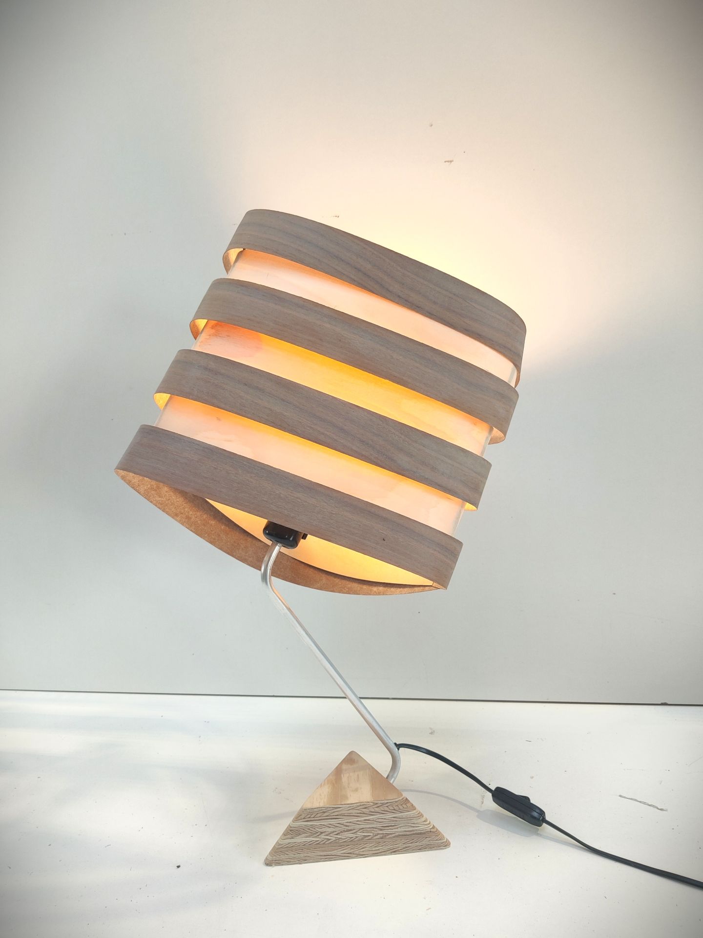 Lampe à poser Nest Duo en bois de bouleau et noyer, luminaire design Tectoluce avec base triangulaire et lumière chaude.